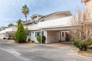 View of front of property featuring a balcony and asphalt driveway
