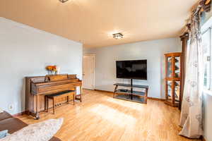 Living room featuring light wood-style floors and baseboards