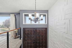 Entrance foyer featuring hanging lights and a textured ceiling