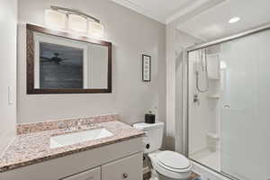 Full bath featuring vanity, a stall shower, crown molding, and recessed lighting
