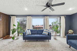 Living room with carpet flooring, ceiling fan, a textured ceiling, plenty of natural light, and recessed lighting