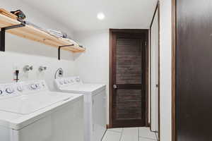 Laundry room featuring washer and dryer, light tile patterned flooring, and recessed lighting