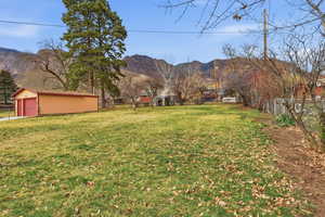 View of yard featuring an outbuilding, a mountain view, and a garage