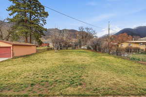 View of yard with a mountain view and a garage