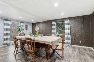 Dining room featuring healthy amount of natural light, wood finished floors, and recessed lighting