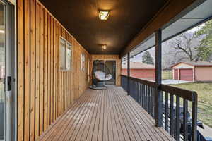 Wooden deck featuring an outbuilding and a garage