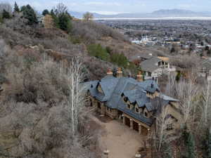 Aerial view of property and surrounding area featuring mountains and nearby suburban area