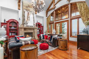 Living area with vaulted ceiling, a fireplace, wood finished floors, and hanging lights