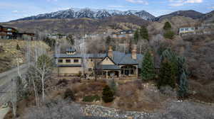 Rear view of house featuring a mountain view, a chimney, and a patio