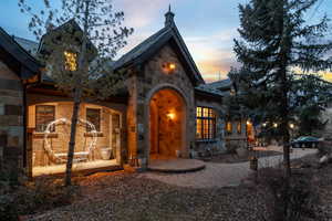 View of front of property with stone siding and a patio