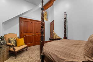 Carpeted bedroom with lofted ceiling