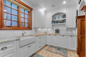Kitchen with light stone countertops, white cabinetry, open shelves, light floors, and recessed lighting