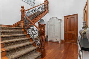 Stairway with a high ceiling and hardwood / wood-style floors