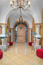 Entrance foyer featuring arched walkways, hanging lights, and a high barrel ceiling