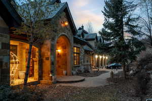 Property exterior at dusk featuring stone siding and a patio area