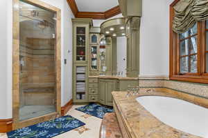 Bathroom with vanity, a stall shower, crown molding, light tile patterned flooring, and a garden tub