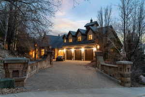 View of front of house featuring a chimney and decorative driveway
