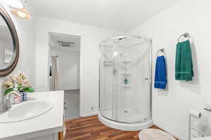 Full bathroom with vanity, dark wood-style floors, a stall shower, and cooling unit