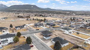 Aerial overview of property's location featuring a mountain backdrop and nearby suburban area