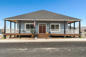 View of front of house featuring roof with shingles and a porch