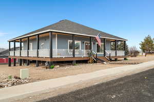 View of front of home featuring roof with shingles and covered porch