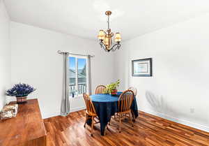Dining room with wood finished floors and hanging lights