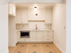 Built-in stainless steel microwave within custom cabinetry featuring gold-tone hardware