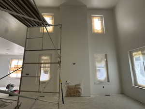 Living room with a high ceiling, fireplace and plenty of natural light