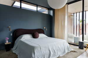 Bedroom 2 with a Floor to Celing Windows, Exterior Door, & Speakers