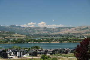 Water view with nearby suburban area and a mountain backdrop