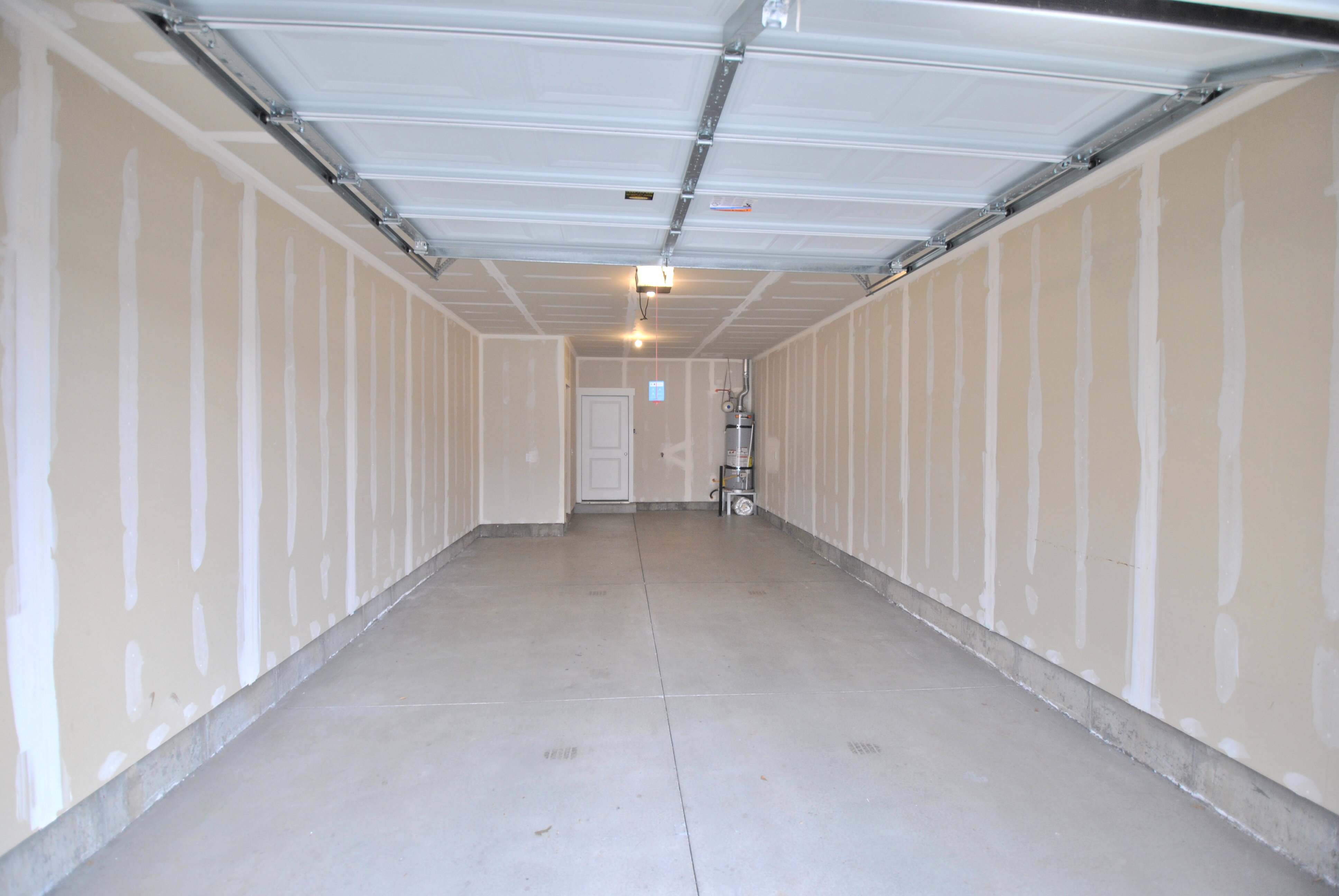 Garage featuring strapped water heater