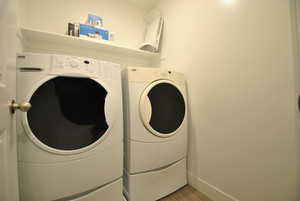 Laundry room featuring washing machine and clothes dryer and wood finished floors