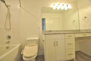 Primary full bath featuring vanity, shower / washtub combination, and dark wood-type flooring