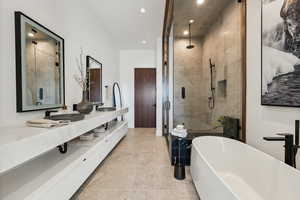 Bathroom with a shower stall, double vanity, a freestanding bath, and recessed lighting