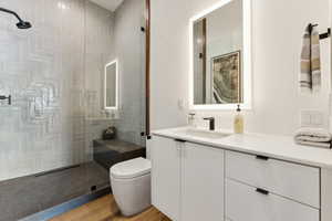 Bathroom with vanity, a walk in shower, and light wood-type flooring