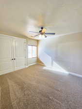 Unfurnished bedroom with a closet, carpet, and ceiling fan