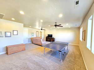 Recreation room with recessed lighting, light colored carpet, and ceiling fan