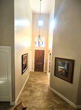 Foyer entrance with arched walkways, a high ceiling, and hanging lights
