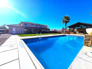 Outdoor pool featuring a patio and a lawn