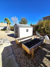 View of yard with a garden and a storage shed