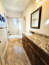 Bathroom featuring shower / bath combination with curtain and vanity