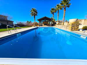 Swimming pool featuring a patio and a fenced backyard