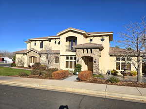 Mediterranean / spanish-style house featuring stone siding, stucco siding, and a tile roof
