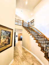 Staircase featuring a high ceiling and recessed lighting