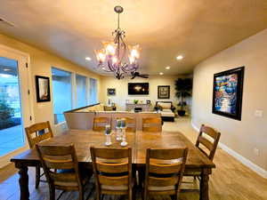 Dining area featuring a chandelier, a fireplace, light wood finished floors, and a ceiling fan