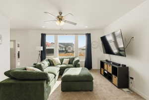 Living room featuring light colored carpet, a ceiling fan, and recessed lighting