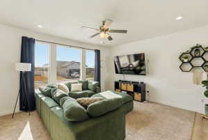 Living room featuring a ceiling fan, recessed lighting, and light colored carpet