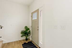 Foyer with light wood finished floors and baseboards