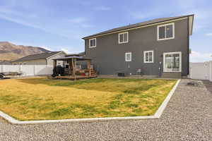 Back of house with a gate, a gazebo, a fenced backyard, a patio, and a deck with mountain view