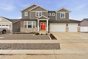 Craftsman inspired home featuring stone siding, driveway, and an attached garage